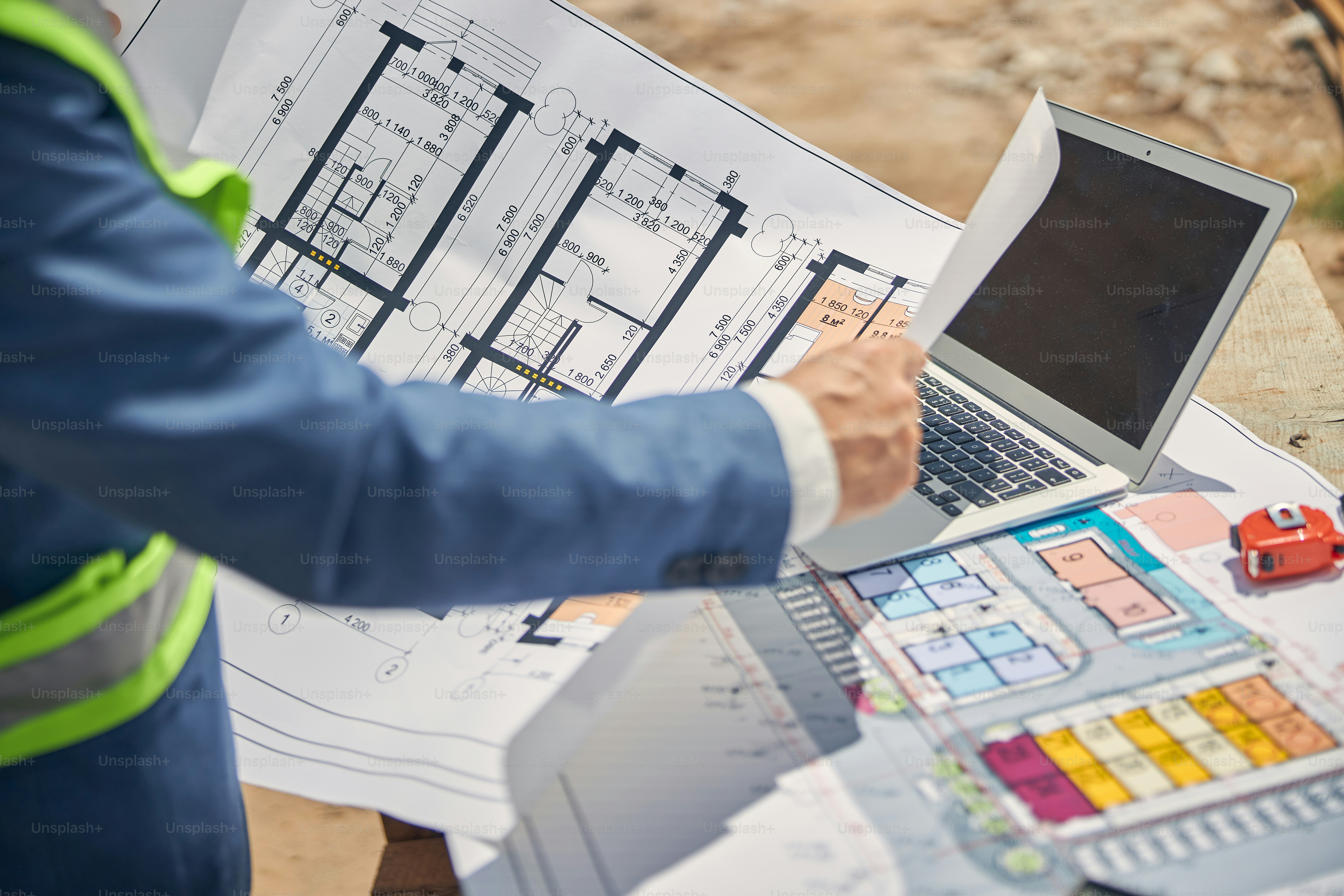 Cropped photo of an experienced Caucasian civil engineer examining the house plan in his hands